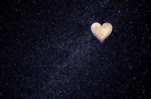 black sky filled with stars and the moon in the shape of a heart.