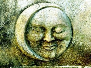 stone carving of a moon with a face