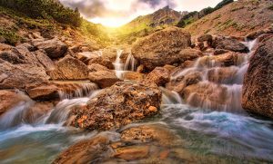 sprawling cascading waterfall with sunrise in the background