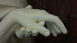 close up statue of a hand helping another hand