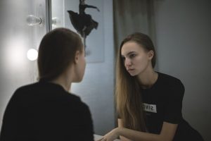 Reflection of young woman looking in a mirror